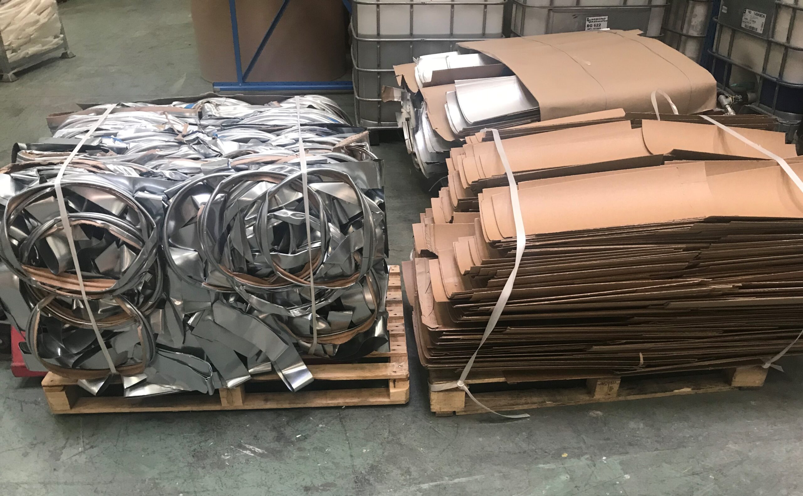 Two pallets packed with steel and paper components of used Enviroloc drums