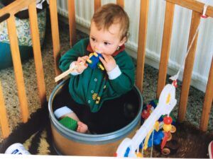 Rob Lee as a baby in a fibre drum inside a playpen