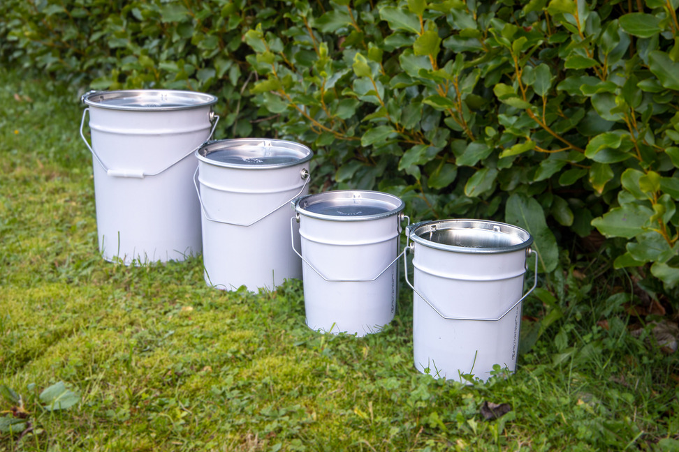 4 metal pails of different sizes on grass